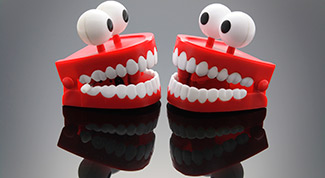 Image of teeth toys against a black background symbolizing the need for dental insurance.